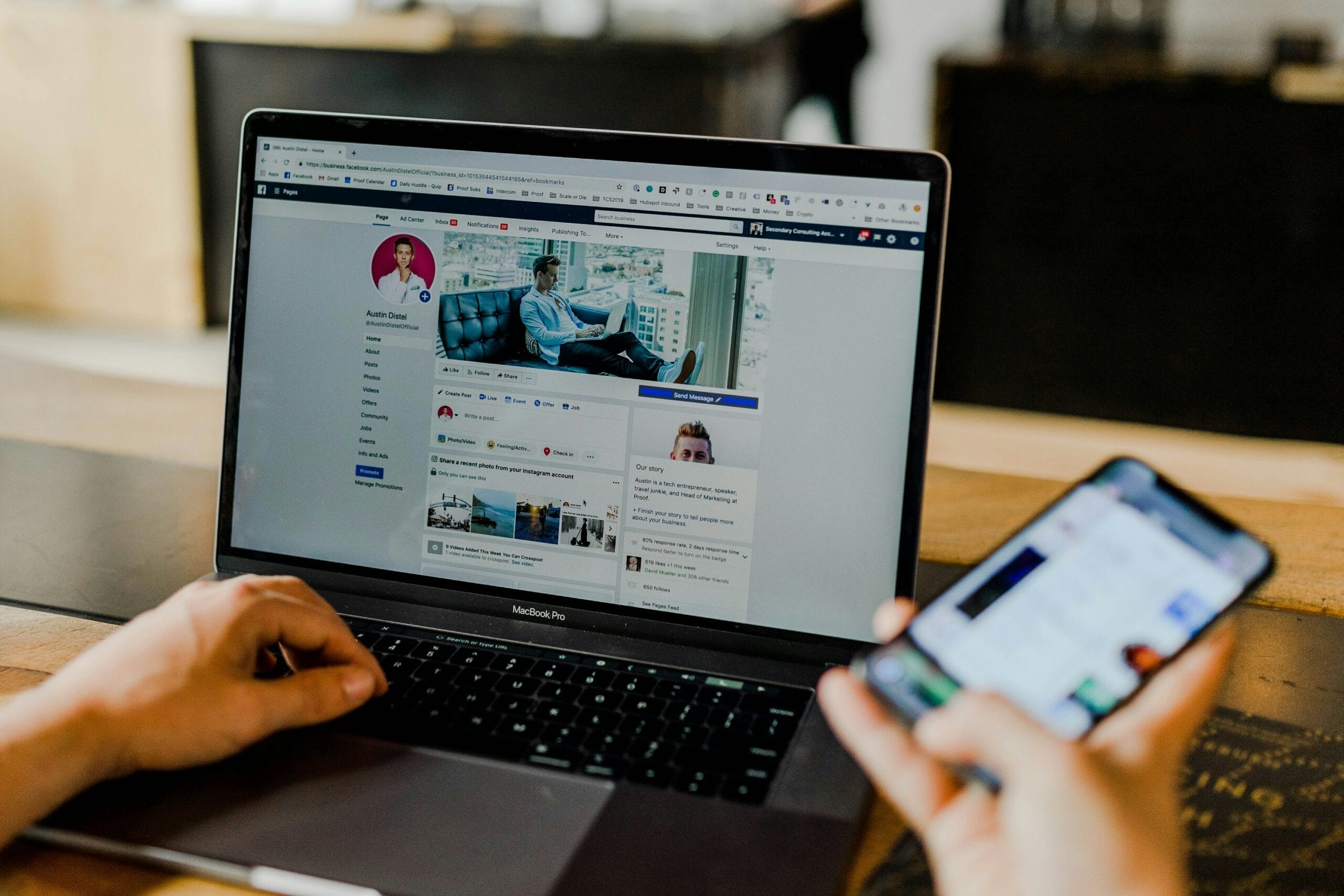 A person using both a laptop and smartphone to create social media content